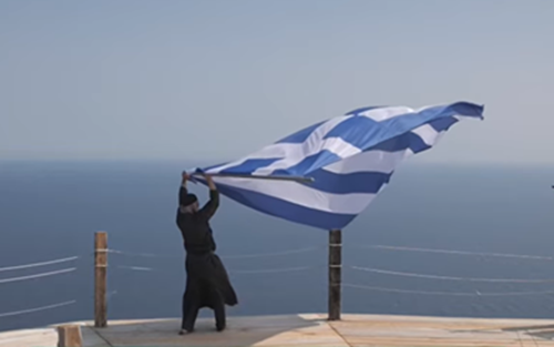 Ο Γέροντας Ιωσήφ στη Βίγλα του Αγίου Όρους κρατώντας την ελληνική σημαία